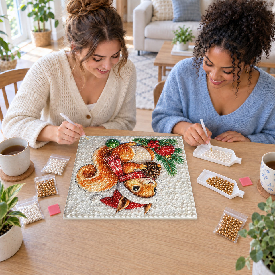 Two friends creating one shared Pearl artwork — Christmas Squirrel with a Pinecone. Pearl diamond painting DIY kit by Isuvio.