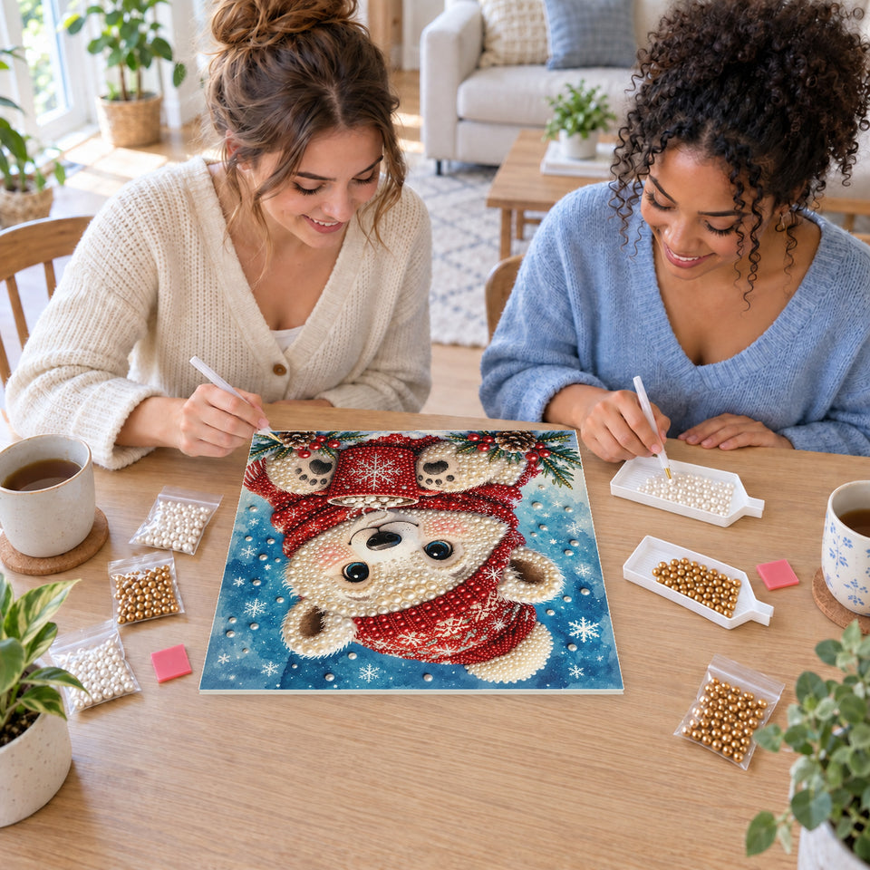 Two friends creating one shared Pearl artwork — Polar Bear Cub with a Red Cocoa Mug. Pearl diamond painting DIY kit by Isuvio.