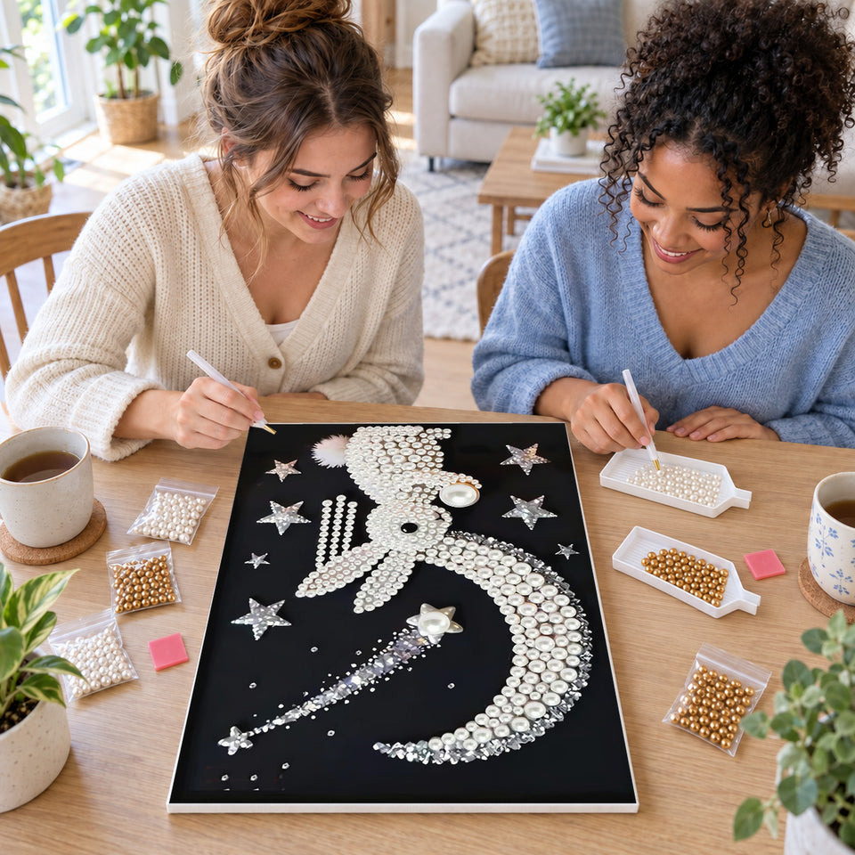Two friends creating one shared Pearl artwork — Pearl Rabbit Beneath a Crescent and Shooting Star. Pearl diamond painting DIY kit by Isuvio.