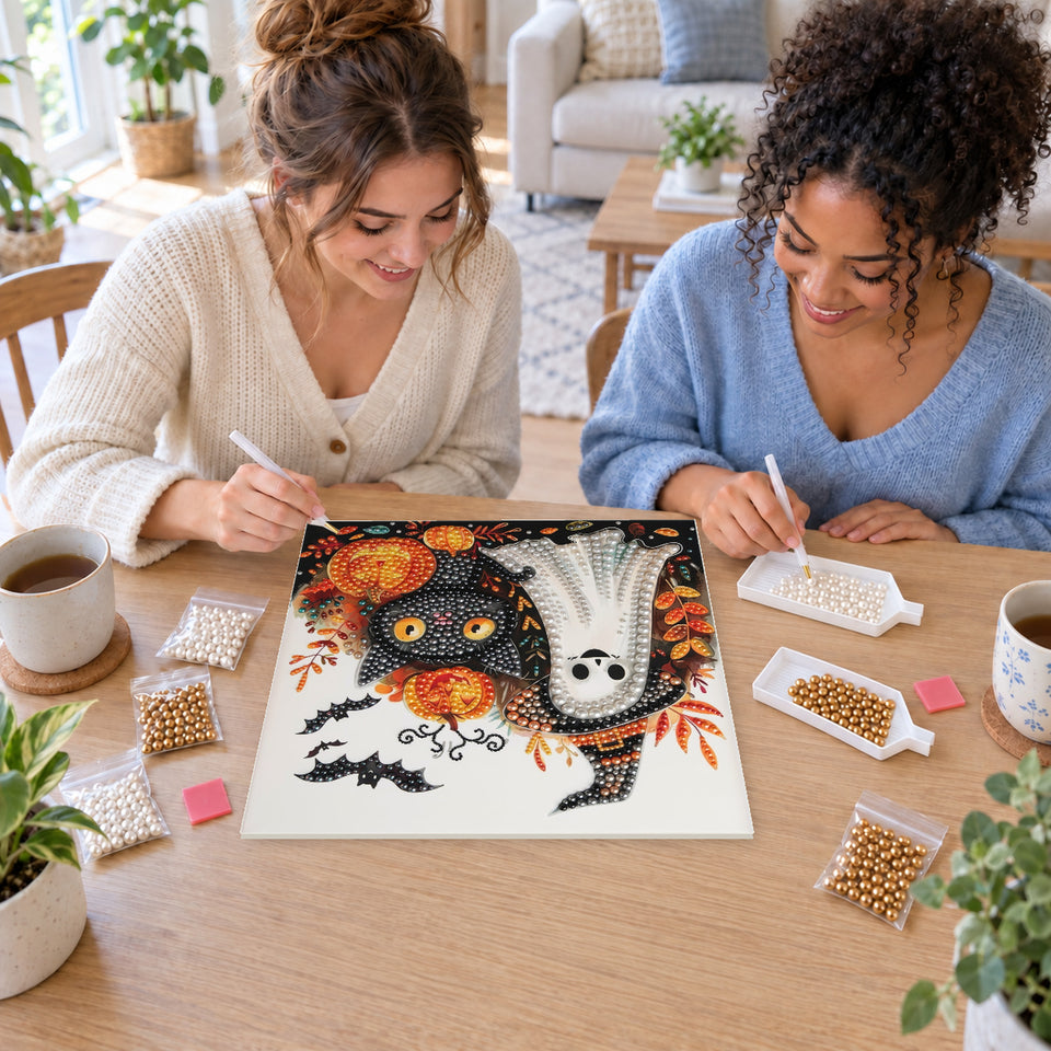 Two friends creating one shared Pearl artwork — Friendly Ghost and Black Cat Among Pumpkins. Pearl diamond painting DIY kit by Isuvio.