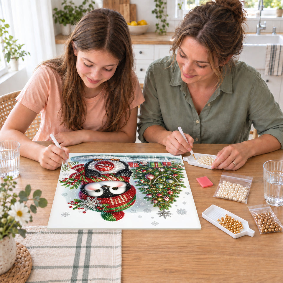Mother and daughter creating one shared Pearl artwork — Penguin with a Merry Christmas Bauble. Pearl diamond painting DIY kit by Isuvio.