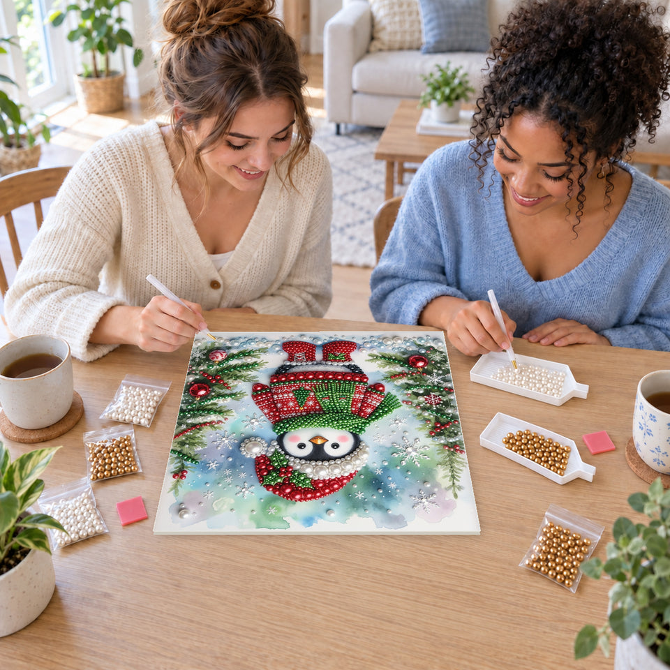 Two friends creating one shared Pearl artwork — Snowy Penguin in a Christmas Sweater. Pearl diamond painting DIY kit by Isuvio.