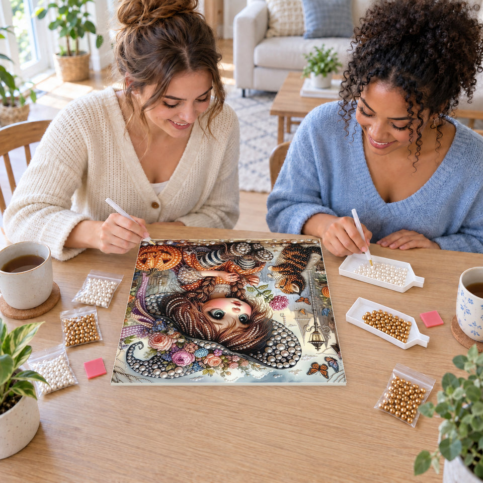 Two friends creating one shared Pearl artwork — Little Floral-Hat Witch with a Tabby Kitten. Pearl diamond painting DIY kit by Isuvio.