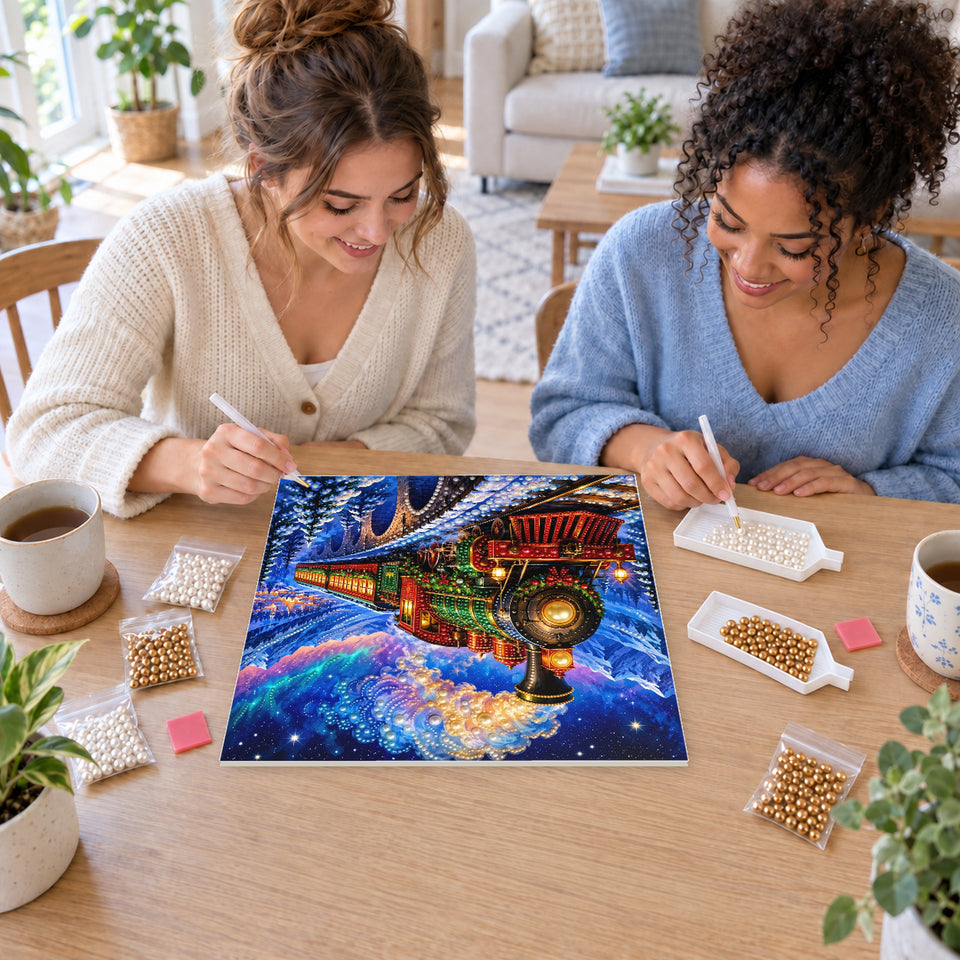 Two friends creating one shared Pearl artwork — Christmas Train beneath the Northern Lights. Pearl diamond painting DIY kit by Isuvio.