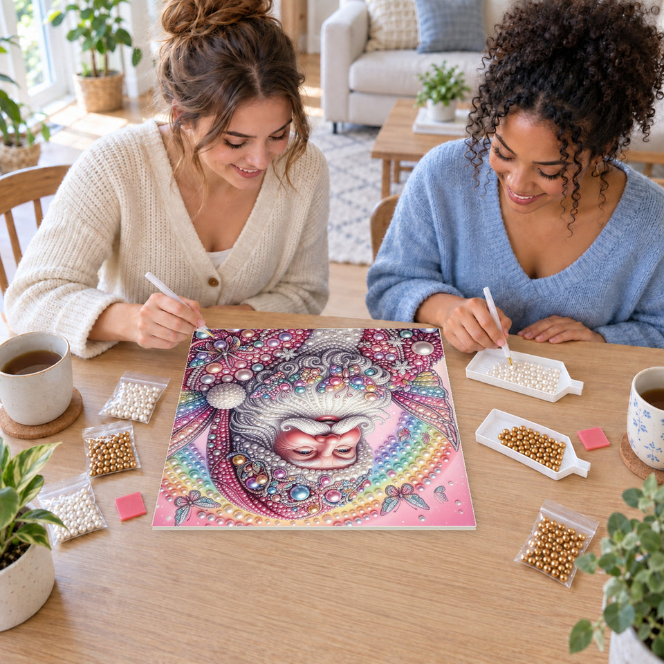 Two friends creating one shared Pearl artwork — Pink Fairy Santa beneath a Rainbow. Pearl diamond painting DIY kit by Isuvio.