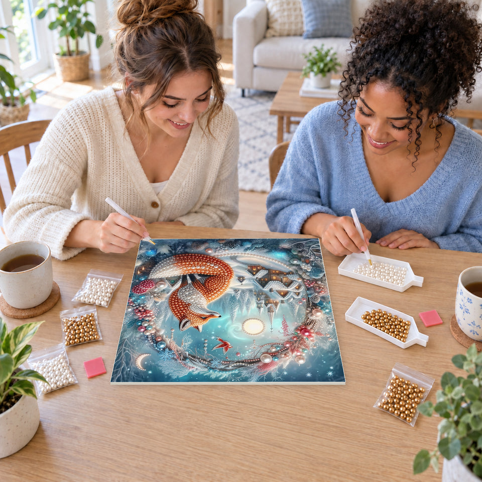 Two friends creating one shared Pearl artwork — Winter Fox in a Moonlit Village Wreath. Pearl diamond painting DIY kit by Isuvio.