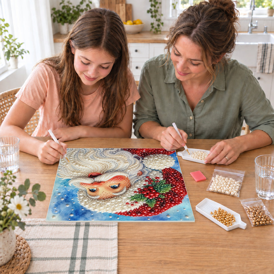 Mother and daughter creating one shared Pearl artwork — Smiling Santa beneath a Snowy Blue Sky. Pearl diamond painting DIY kit by Isuvio.