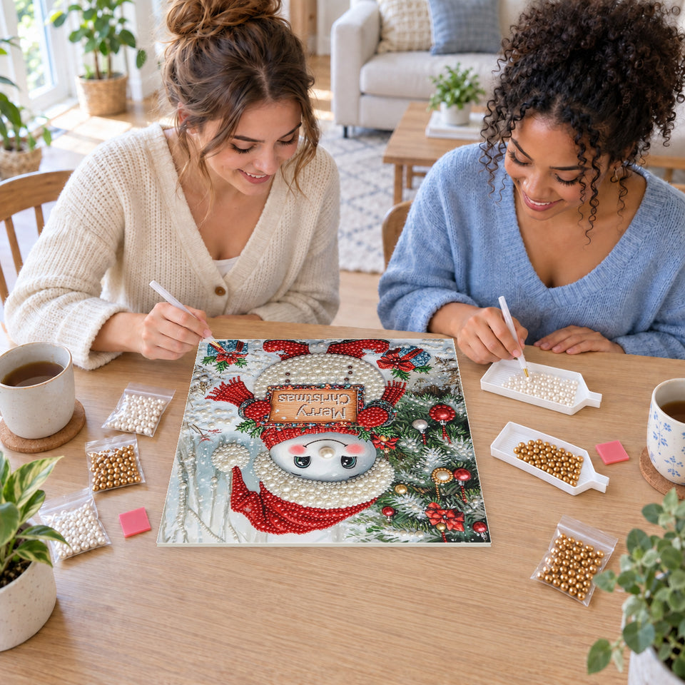 Two friends creating one shared Pearl artwork — Snowman with a Merry Christmas Sign. Pearl diamond painting DIY kit by Isuvio.