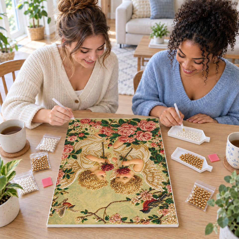 Two friends creating one shared Pearl artwork — Two Cherubs Among Pink Roses and Birds. Pearl diamond painting DIY kit by Isuvio.