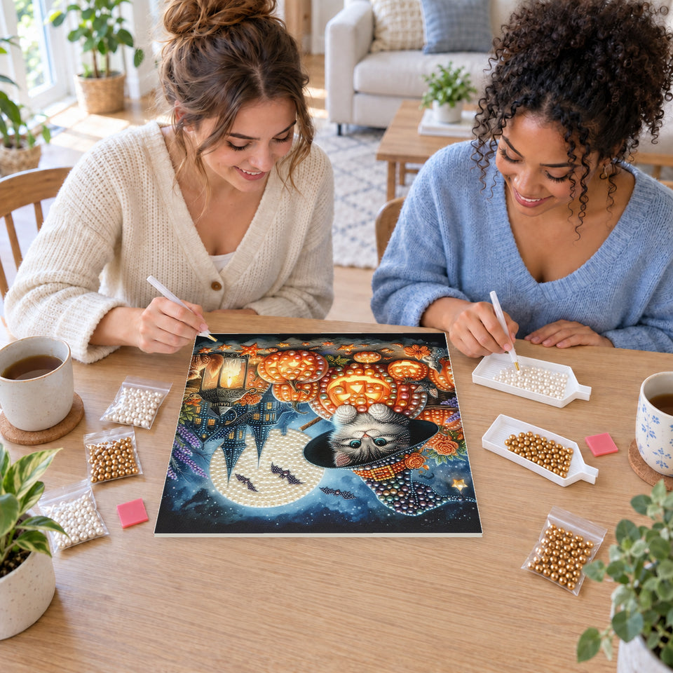 Two friends creating one shared Pearl artwork — Witch Kitten among Glowing Pumpkin Lanterns. Pearl diamond painting DIY kit by Isuvio.