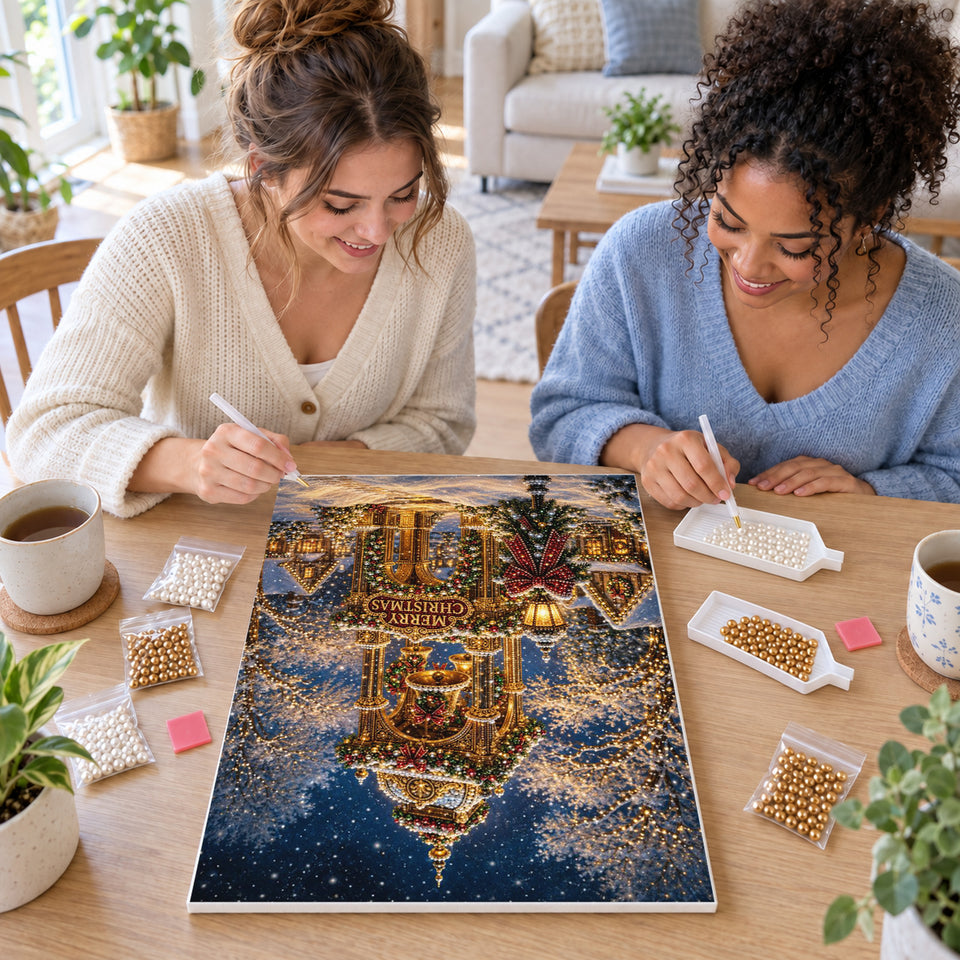 Two friends creating one shared Pearl artwork — Golden Christmas Bell Tower in the Snow. Pearl diamond painting DIY kit by Isuvio.