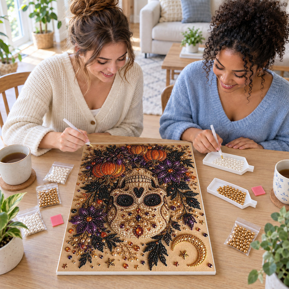 Two friends creating one shared Pearl artwork — Golden Skull with Purple Flowers and Pumpkins. Pearl diamond painting DIY kit by Isuvio.