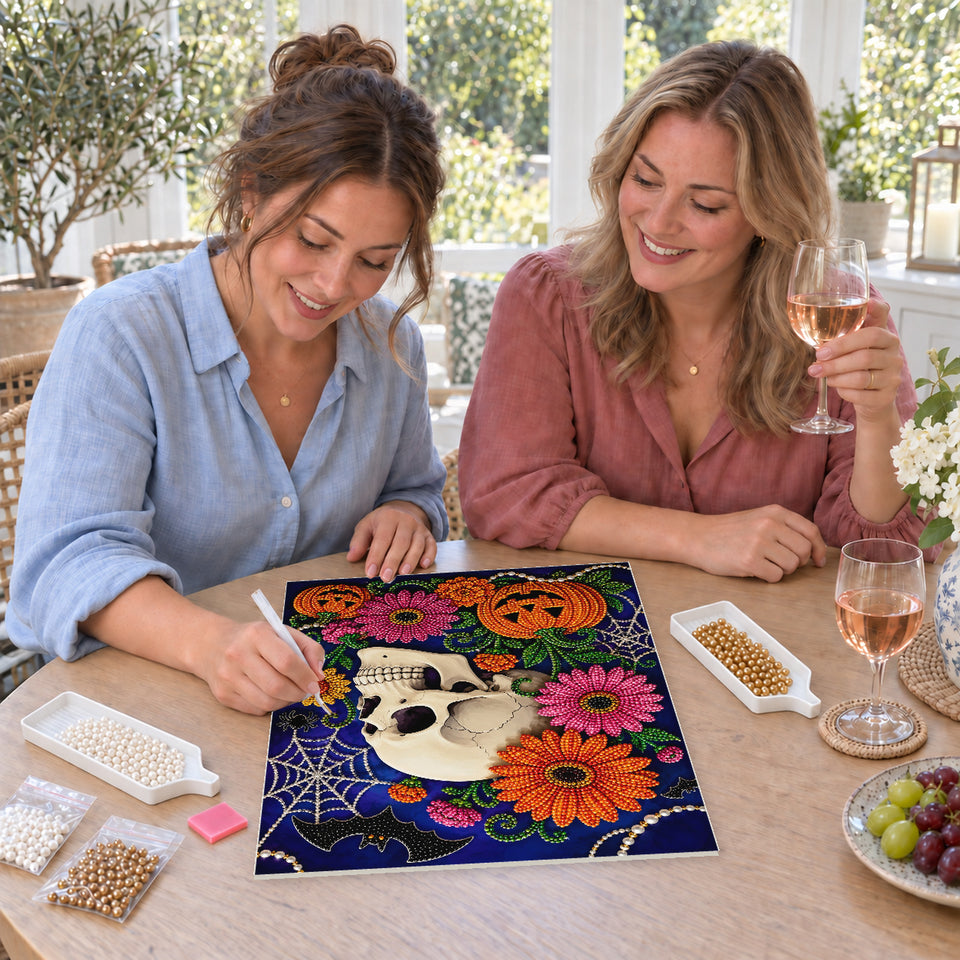 Friends enjoying a sip and craft session — Floral Skull with Pink Blossoms and Pumpkins. Pearl diamond painting DIY kit by Isuvio.