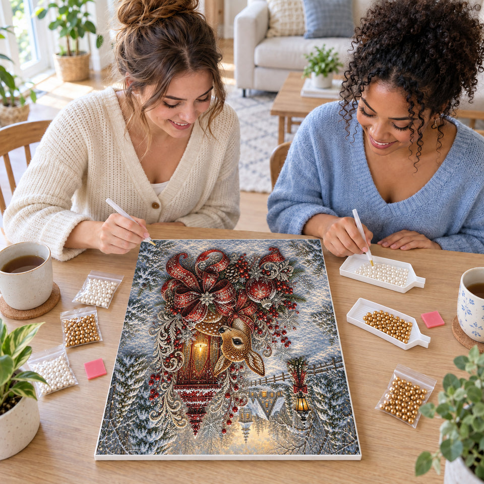 Two friends creating one shared Pearl artwork — Winter Fawn Beside a Red Christmas Lantern. Pearl diamond painting DIY kit by Isuvio.