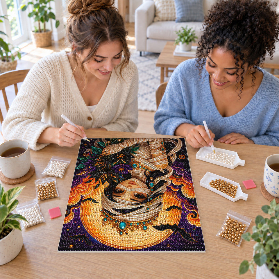 Two friends creating one shared Pearl artwork — Mummy Princess with a Crown and Autumn Bouquet. Pearl diamond painting DIY kit by Isuvio.