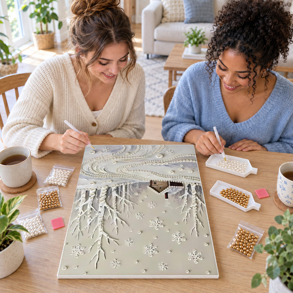 Two friends creating one shared Pearl artwork — Snowy Woodland Cabin and Winding Pearl Path. Pearl diamond painting DIY kit by Isuvio.