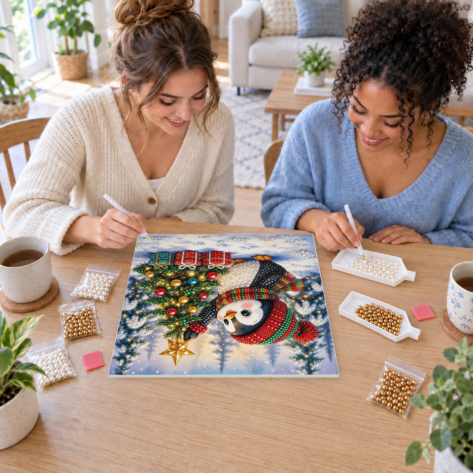 Two friends creating one shared Pearl artwork — Penguin Reaching for a Christmas Star. Pearl diamond painting DIY kit by Isuvio.