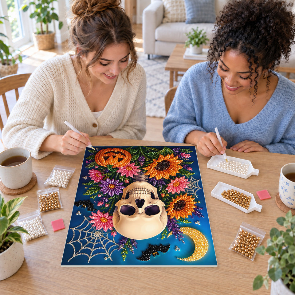 Two friends creating one shared Pearl artwork — Sunflower Skull beneath a Crescent Moon. Pearl diamond painting DIY kit by Isuvio.