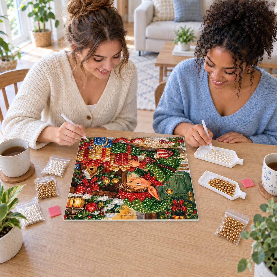Two friends creating one shared Pearl artwork — Christmas Elf Wrapping a Red Present. Pearl diamond painting DIY kit by Isuvio.