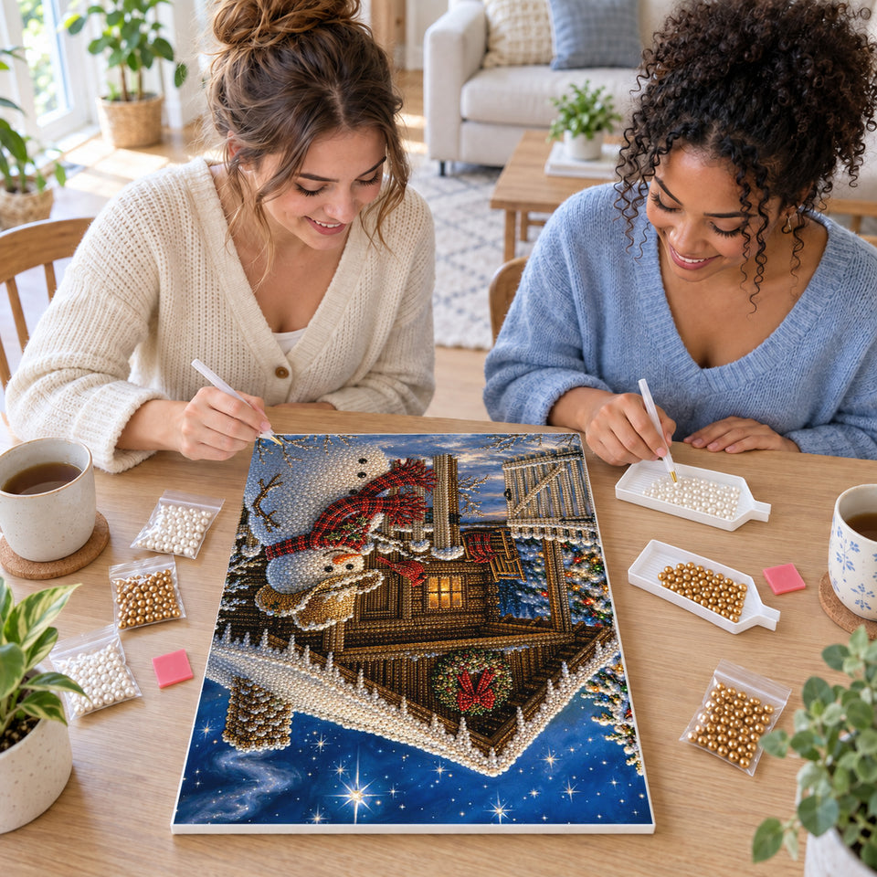 Two friends creating one shared Pearl artwork — Snowman in a Cowboy Hat Beside a Christmas Cabin. Pearl diamond painting DIY kit by Isuvio.