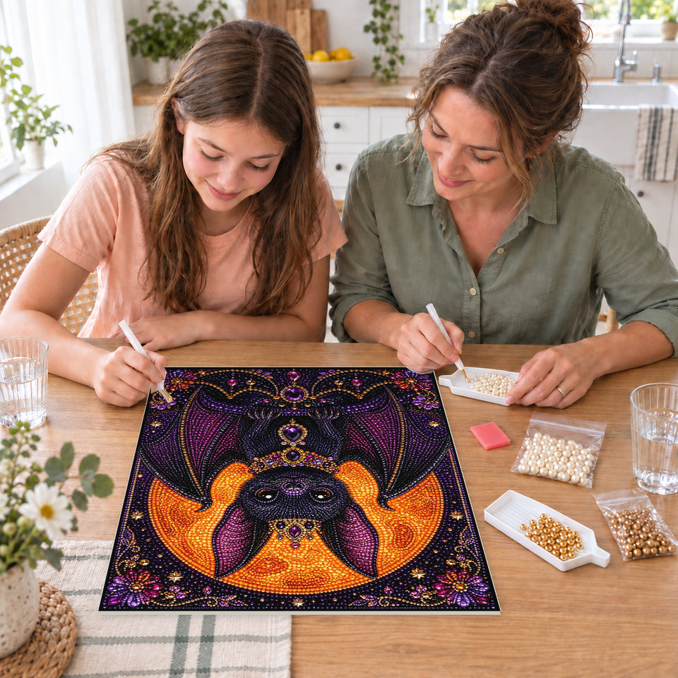 Mother and daughter creating one shared Pearl artwork — Jeweled Purple Bat Beneath a Harvest Moon. Pearl diamond painting DIY kit by Isuvio.