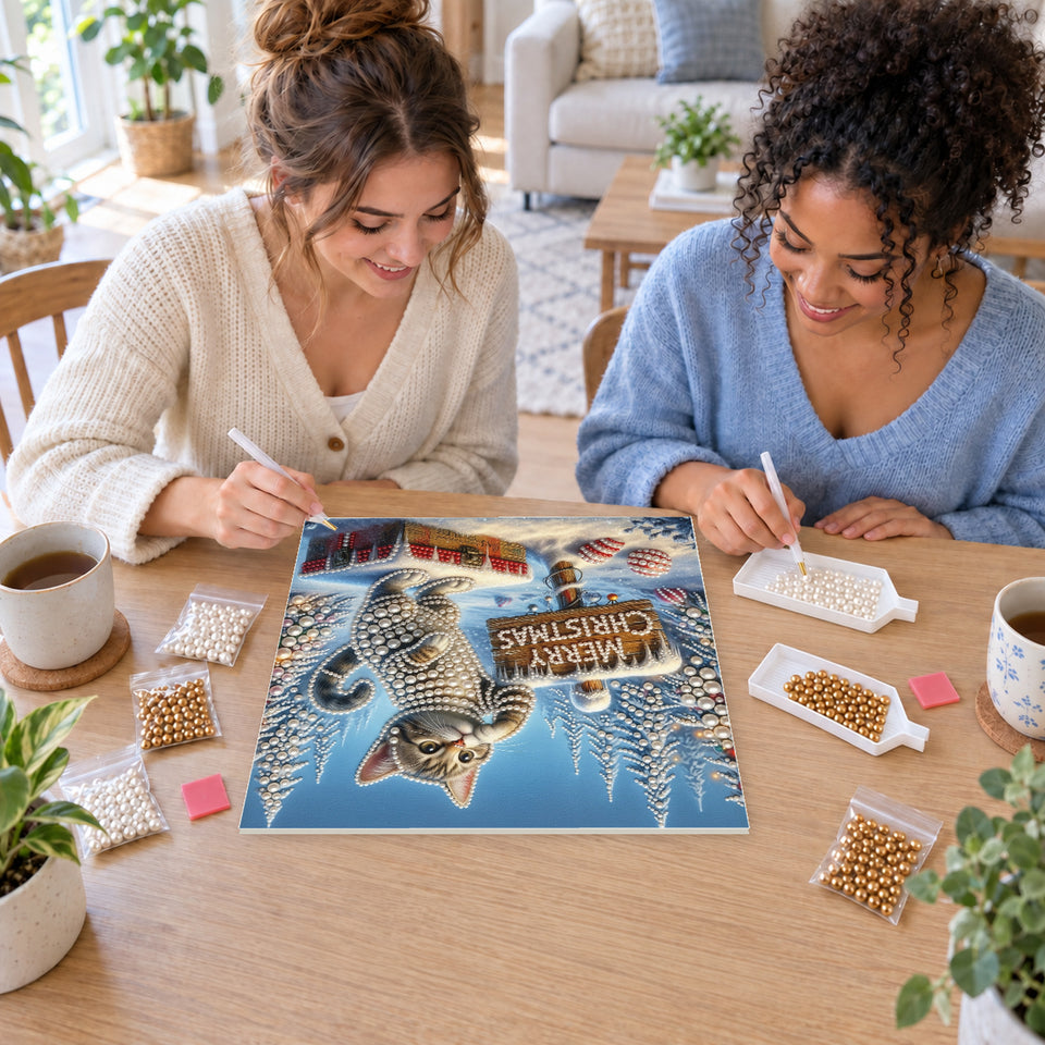 Two friends creating one shared Pearl artwork — Merry Christmas Kitten on a Gift Box. Pearl diamond painting DIY kit by Isuvio.