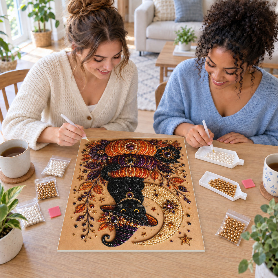 Two friends creating one shared Pearl artwork — Black Cat on Stacked Pumpkins Beneath a Crescent Moon. Pearl diamond painting DIY kit by Isuvio.