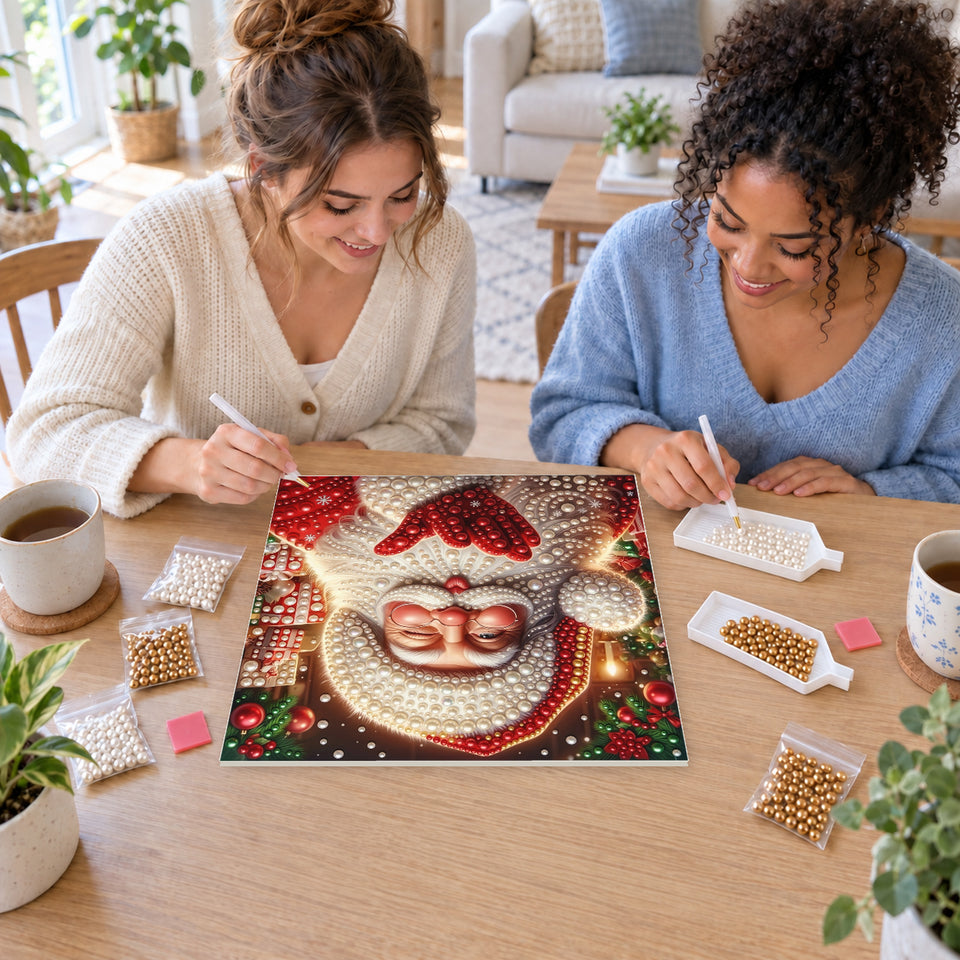 Two friends creating one shared Pearl artwork — Santa Blowing a Christmas Kiss. Pearl diamond painting DIY kit by Isuvio.