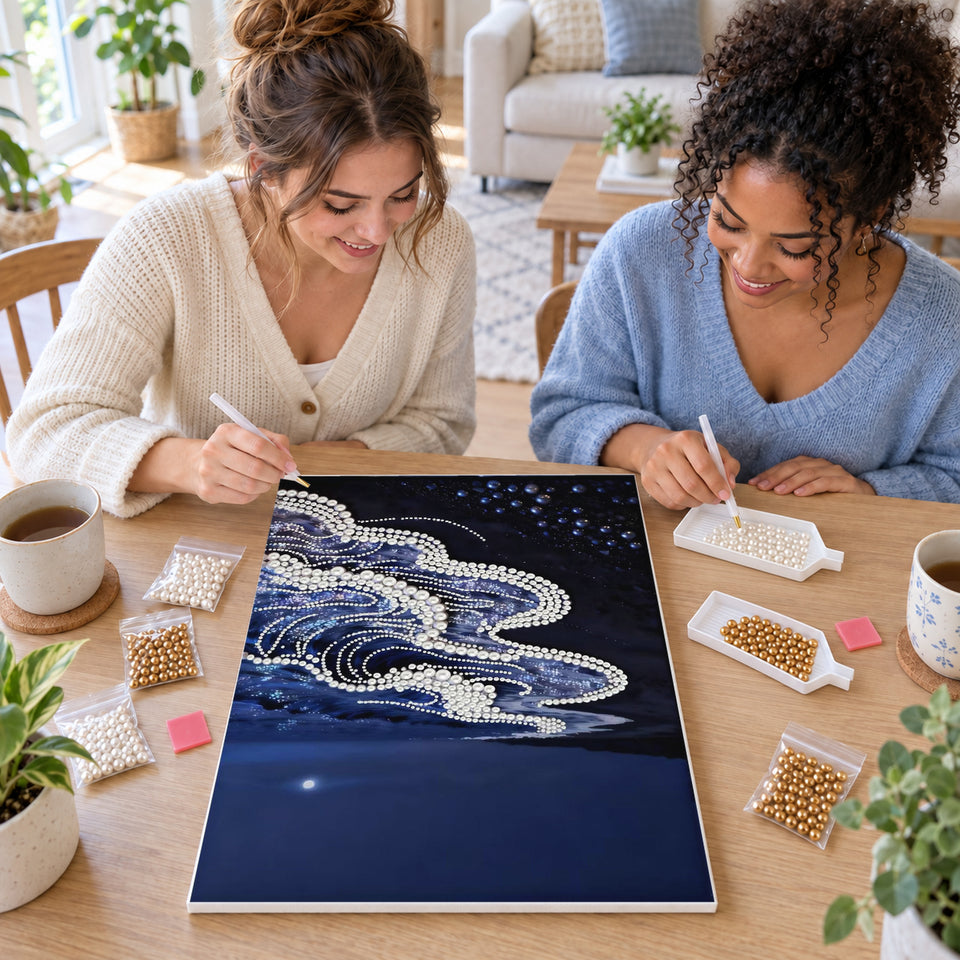 Two friends creating one shared Pearl artwork — White Pearl Waves Along a Midnight Shore. Pearl diamond painting DIY kit by Isuvio.