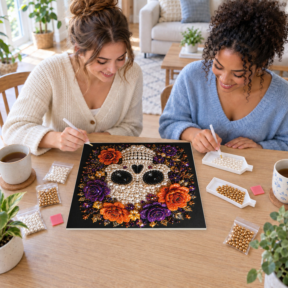 Two friends creating one shared Pearl artwork — White Skull with Purple and Orange Roses. Pearl diamond painting DIY kit by Isuvio.