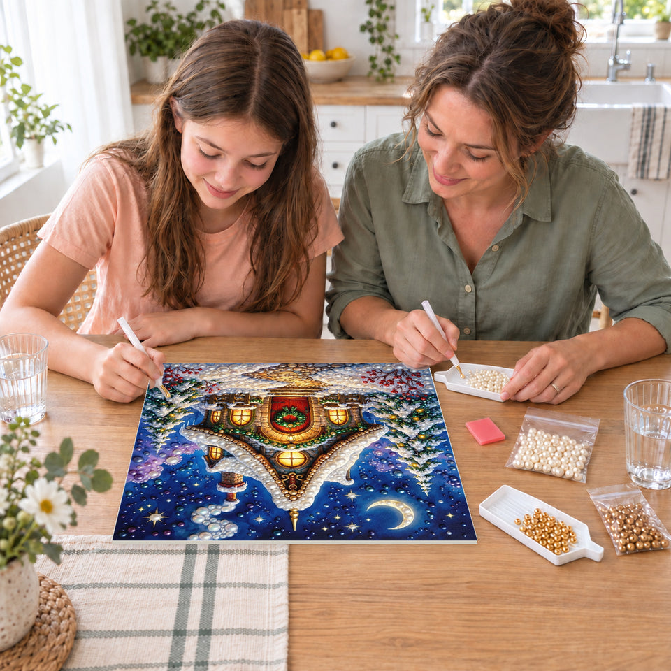 Mother and daughter creating one shared Pearl artwork — Snowy Christmas Cottage beneath a Crescent Moon. Pearl diamond painting DIY kit by Isuvio.