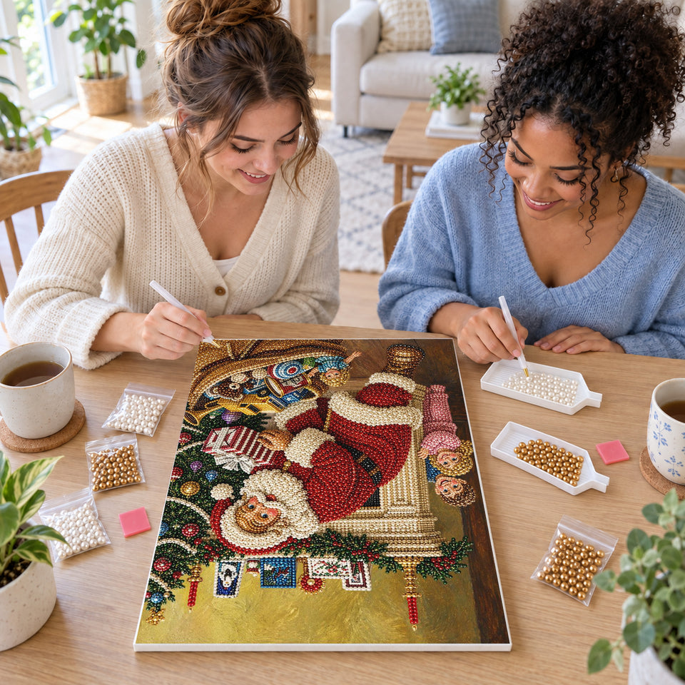 Two friends creating one shared Pearl artwork — Santa Unpacking Toys Beside the Fireplace. Pearl diamond painting DIY kit by Isuvio.