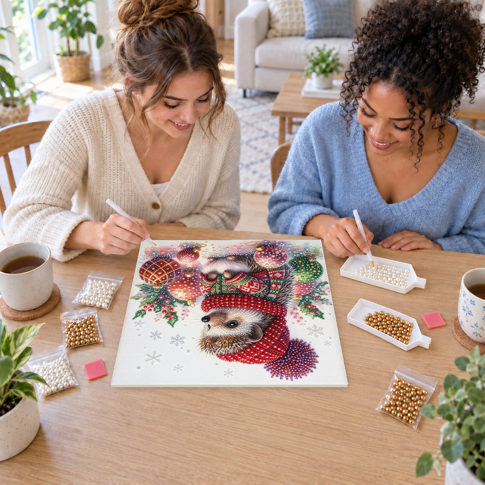 Two friends creating one shared Pearl artwork — Hedgehog in a Christmas Sweater with Ornaments. Pearl diamond painting DIY kit by Isuvio.