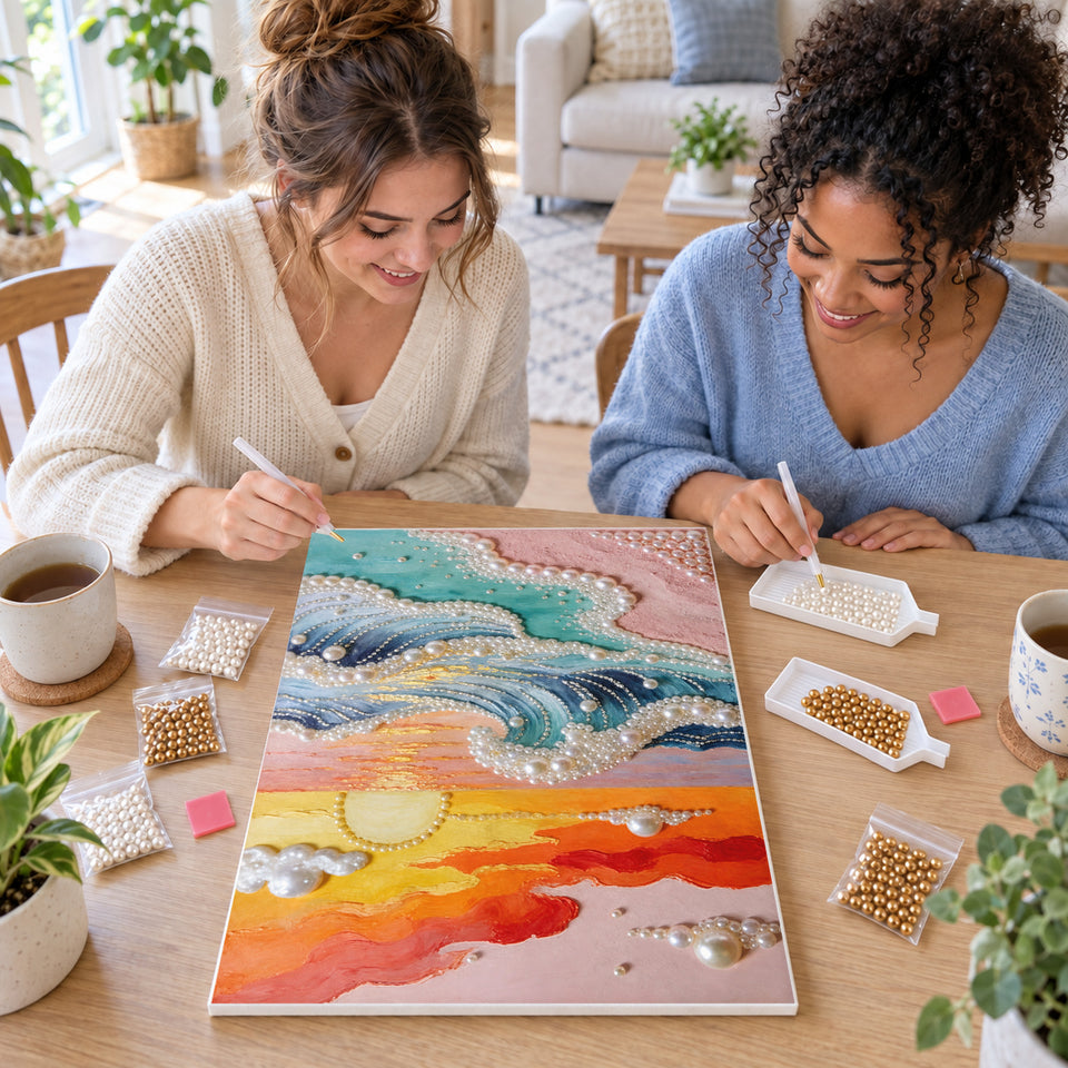 Two friends creating one shared Pearl artwork — Pastel Sunset Over Pearl Ocean Waves. Pearl diamond painting DIY kit by Isuvio.