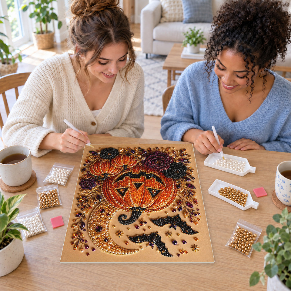 Two friends creating one shared Pearl artwork — Grinning Jack-o'-Lantern with Bats and Dark Roses. Pearl diamond painting DIY kit by Isuvio.