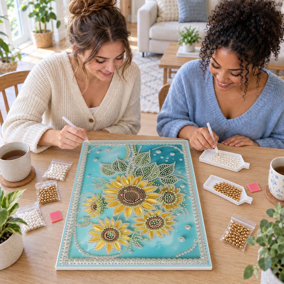 Two friends creating one shared Pearl artwork — Golden Sunflowers on a Turquoise Pearl Background. Pearl diamond painting DIY kit by Isuvio.