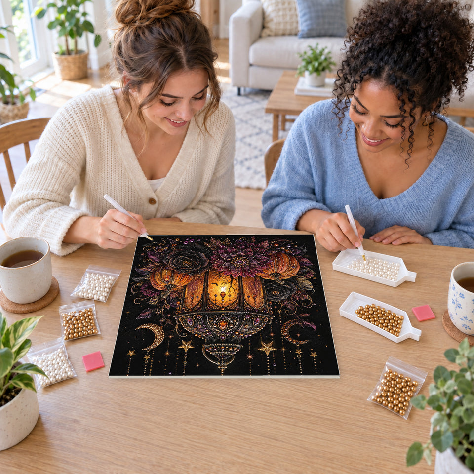 Two friends creating one shared Pearl artwork — Glowing Gothic Lantern with Pumpkins and Dark Flowers. Pearl diamond painting DIY kit by Isuvio.