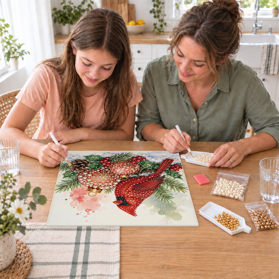 Mother and daughter creating one shared Pearl artwork — Cardinal with Red and Gold Christmas Baubles. Pearl diamond painting DIY kit by Isuvio.