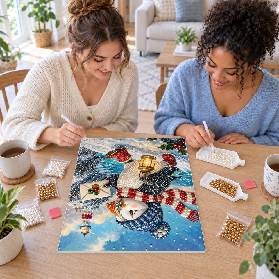Two friends creating one shared Pearl artwork — Winter Puffin with a Lantern by the Lighthouse. Pearl diamond painting DIY kit by Isuvio.