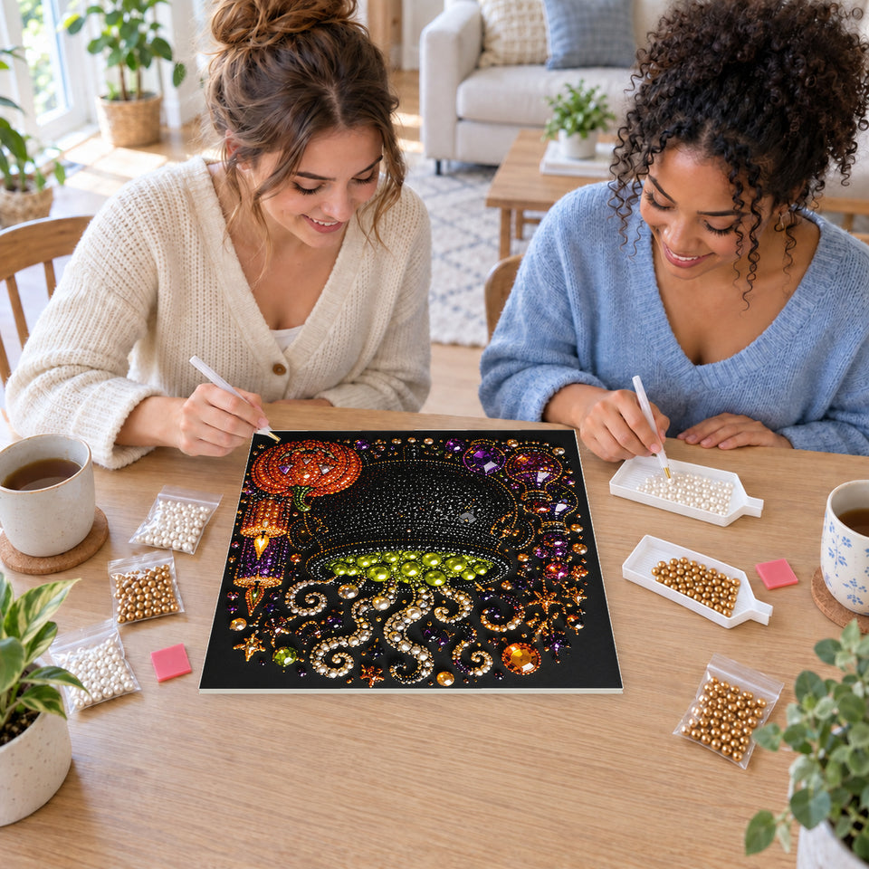 Two friends creating one shared Pearl artwork — Bubbling Green Cauldron with Halloween Candles. Pearl diamond painting DIY kit by Isuvio.