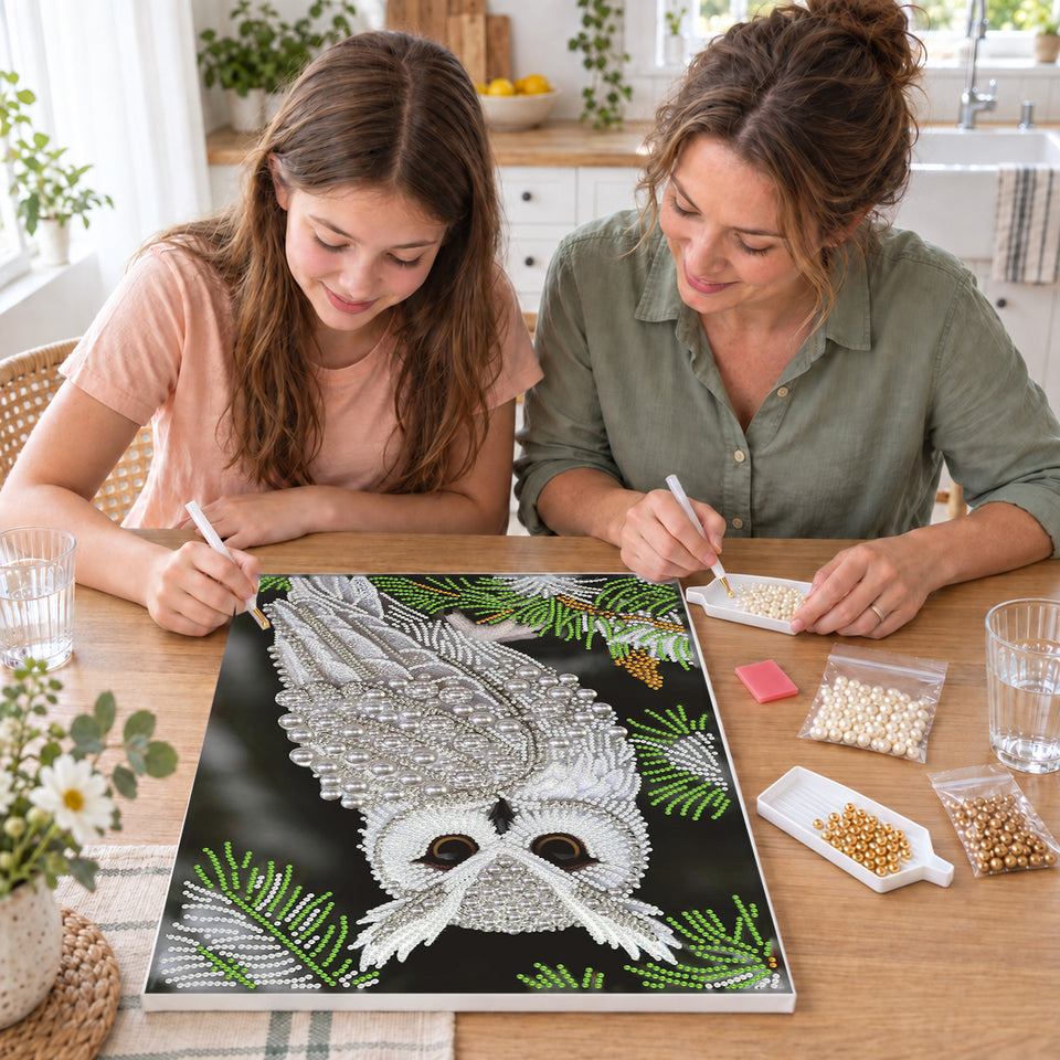 Mother and daughter creating one shared Pearl artwork — White Owl Among Evergreen Branches. Pearl diamond painting DIY kit by Isuvio.