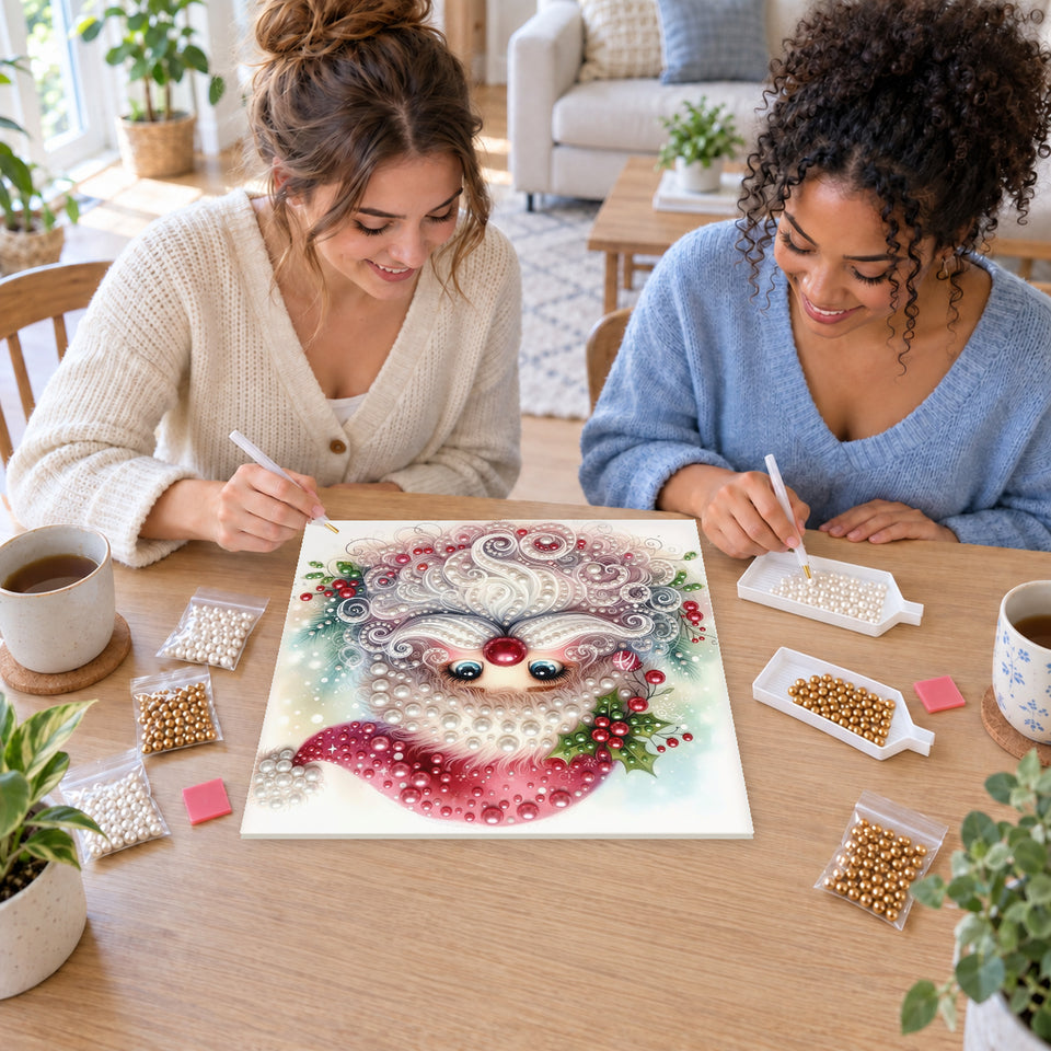 Two friends creating one shared Pearl artwork — Rosy Santa with a Swirling White Beard. Pearl diamond painting DIY kit by Isuvio.
