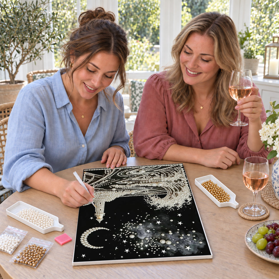 Friends enjoying a sip and craft session — Pearl Lighthouse Beneath a Crescent Moon. Pearl diamond painting DIY kit by Isuvio.