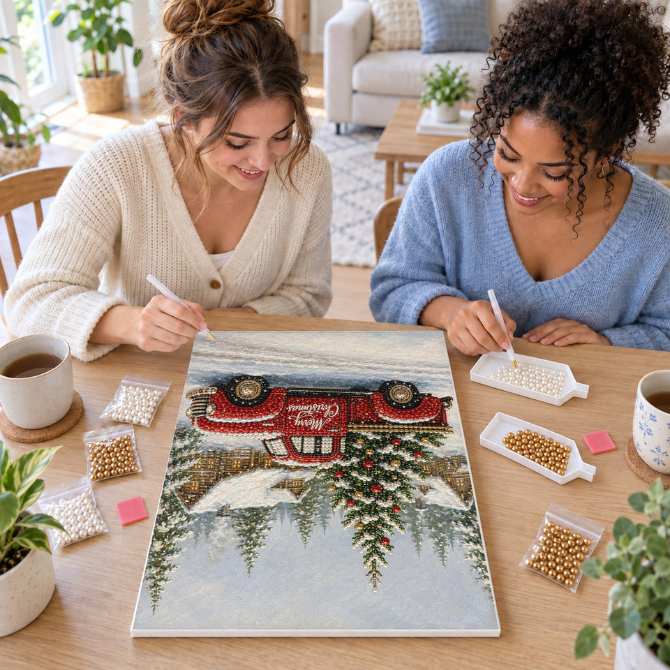 Two friends creating one shared Pearl artwork — Red Christmas Pickup in a Snowy Cottage Village. Pearl diamond painting DIY kit by Isuvio.