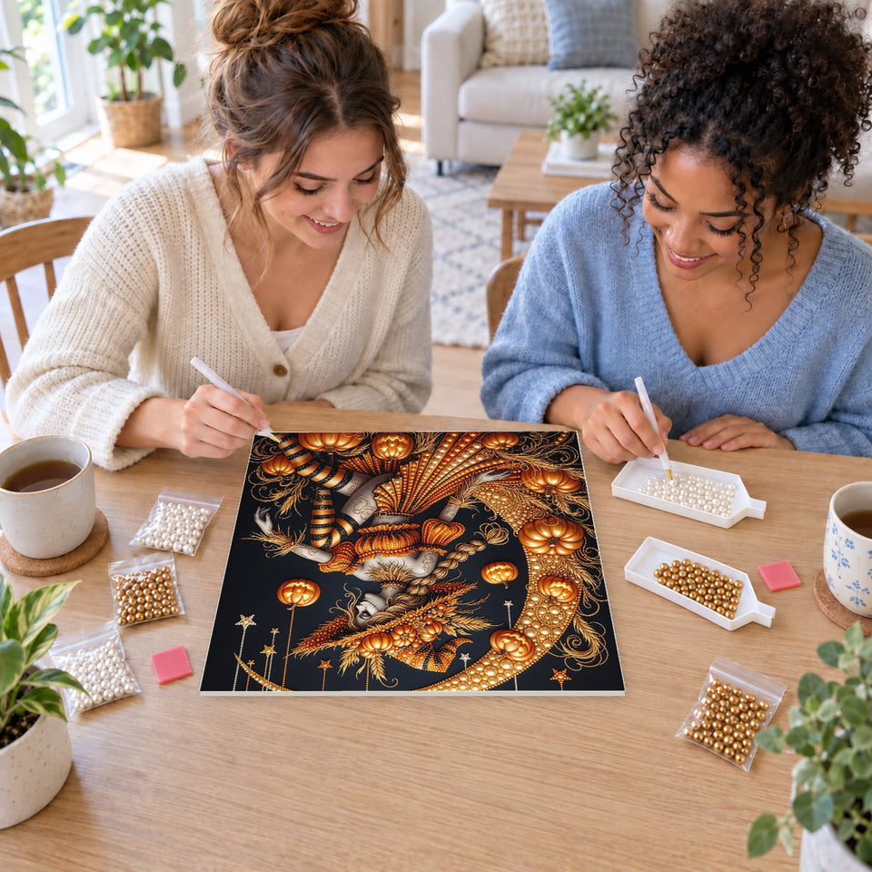 Two friends creating one shared Pearl artwork — Pumpkin Witch on a Golden Crescent Moon. Pearl diamond painting DIY kit by Isuvio.