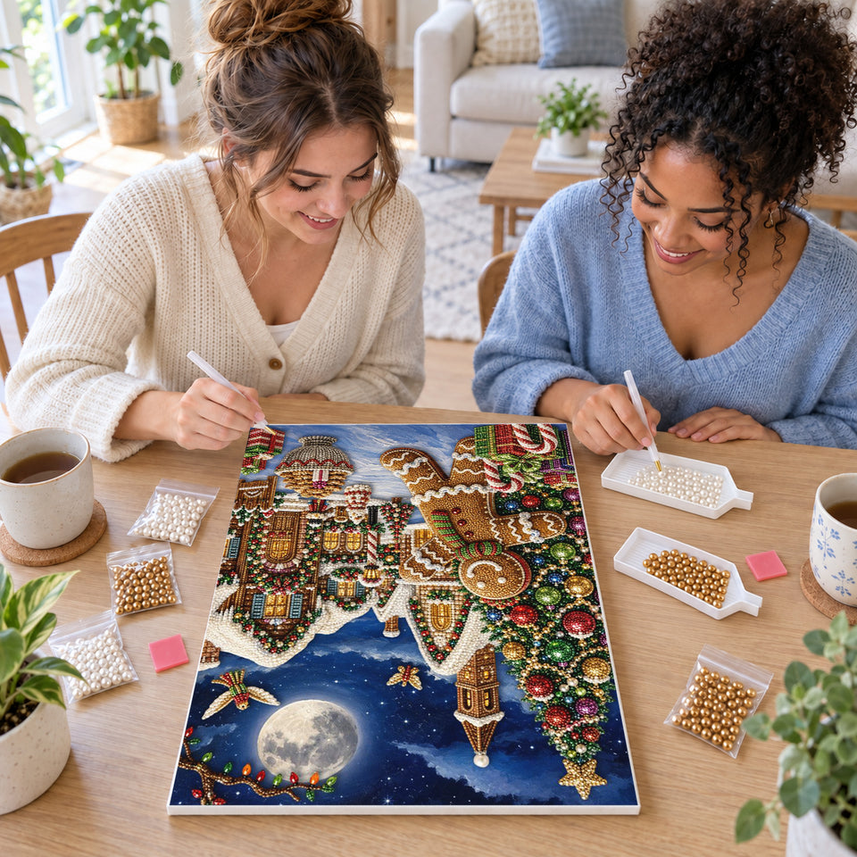 Two friends creating one shared Pearl artwork — Gingerbread Man in a Moonlit Christmas Village. Pearl diamond painting DIY kit by Isuvio.