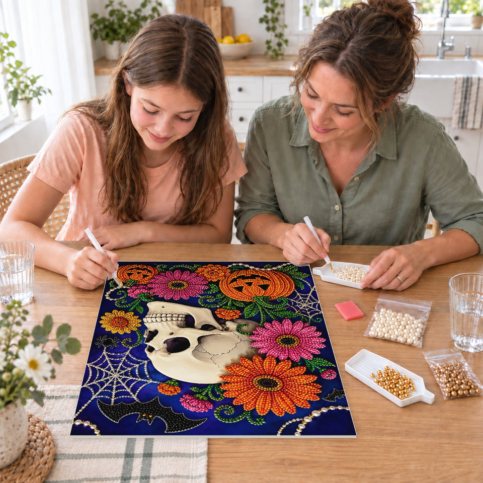 Mother and daughter creating one shared Pearl artwork — Floral Skull with Pink Blossoms and Pumpkins. Pearl diamond painting DIY kit by Isuvio.