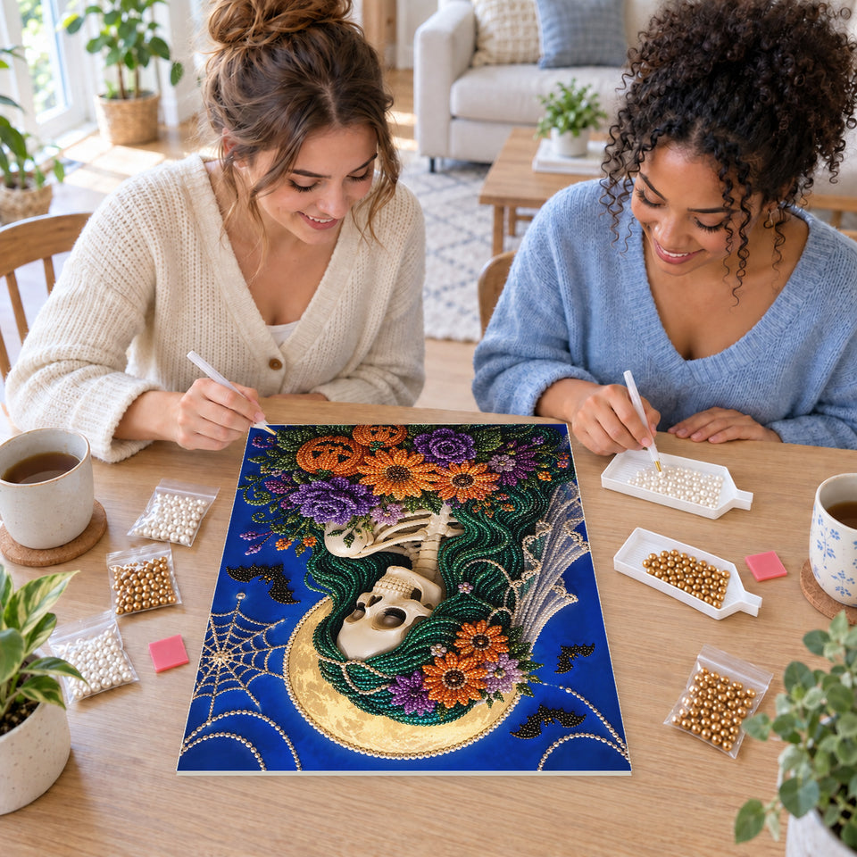 Two friends creating one shared Pearl artwork — Skeleton Bride with a Purple and Orange Bouquet. Pearl diamond painting DIY kit by Isuvio.
